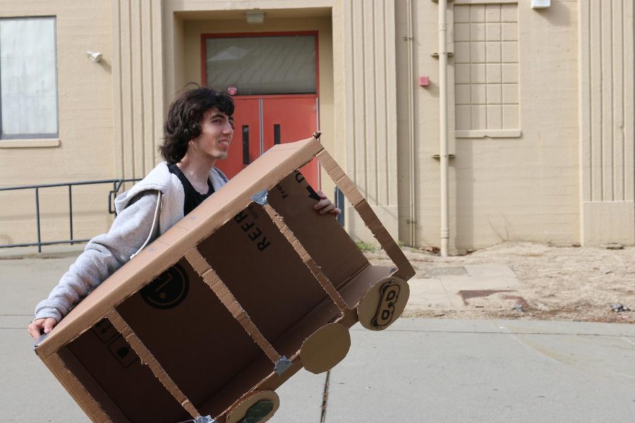 Junior+Ike+Bischof+carries+in+a+cardboard+box+to+use+in+his+self-written+musical.+